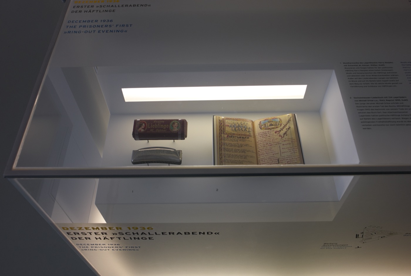 Gedenkstätte Sachsenhausen, Detailbild mit beleuchteten Exponaten in einer Tischvitrine