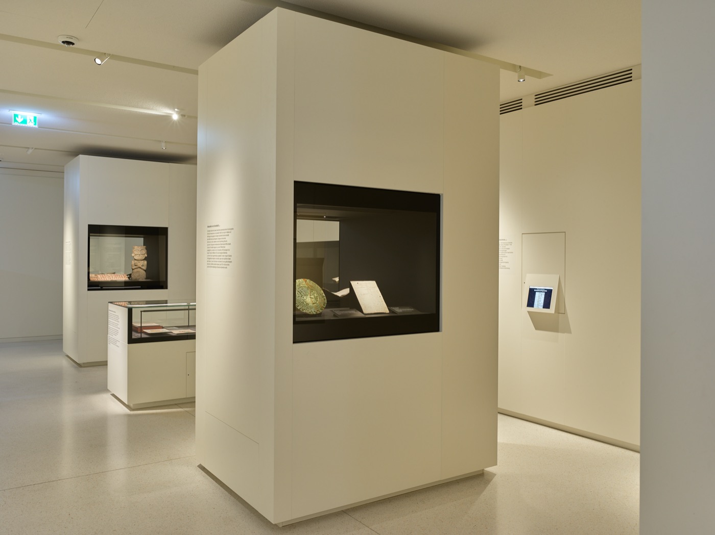 Wechselausstellungsbereich im Stabi-Kulturwerk, helle Wände und Ausstellungsmöbel mit schwarzen Innenflächen und integrierter Beleuchtung, Tischvitrinen und Wandvitrinen